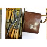 A tin of leather working tools, together with, a leather cased pair of binoculars,