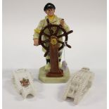 A Royal Doulton figure 1973 HN 2499, the 'Helmsman' together with two World War One tanks,