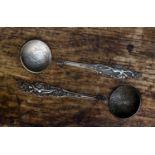 Two Russian coin spoons showing pre natal and post natal female figures,