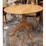 An Ercol light elm pedestal dining table