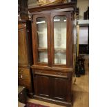 A Victorian mahogany bookcase, the upper section with two glazed doors,