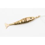 An articulated yellow metal fish, set with garnet eyes, length approx 60mm,