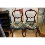 A Victorian set of six walnut balloon back chairs, the backs with carved crest rails,