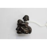 A Japanese dark wood carved Netsuke, depicting a traditionally dressed Japanese woman,