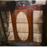 An Edwardian mahogany display cabinet, bowed glass to each side and a central door,