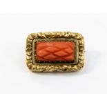 A carved coral brooch,