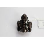 A Japanese dark wood carved Netsuke, depicting an Oriental man in an explicit position,