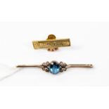 A blue stone set 9ct gold bar brooch with a yellow metal Rolls Royce pin