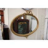 A 19th Century gilt gesso oval mirror, laurel moulded with ribbon bow above,