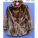 A Mink jacket in dark brown with a wide half belt detail at the back,