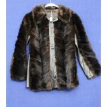 A black Ranch Mink jacket with leather trim down front and leather insets from under arms to base