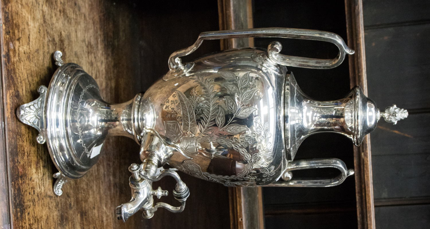 A Victorian EPNS engraved large tea urn, on circular base with four scroll feet,