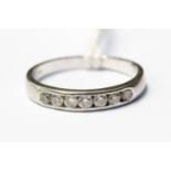 An 18ct white gold diamond half eternity ring, channel set with seven diamonds size J,