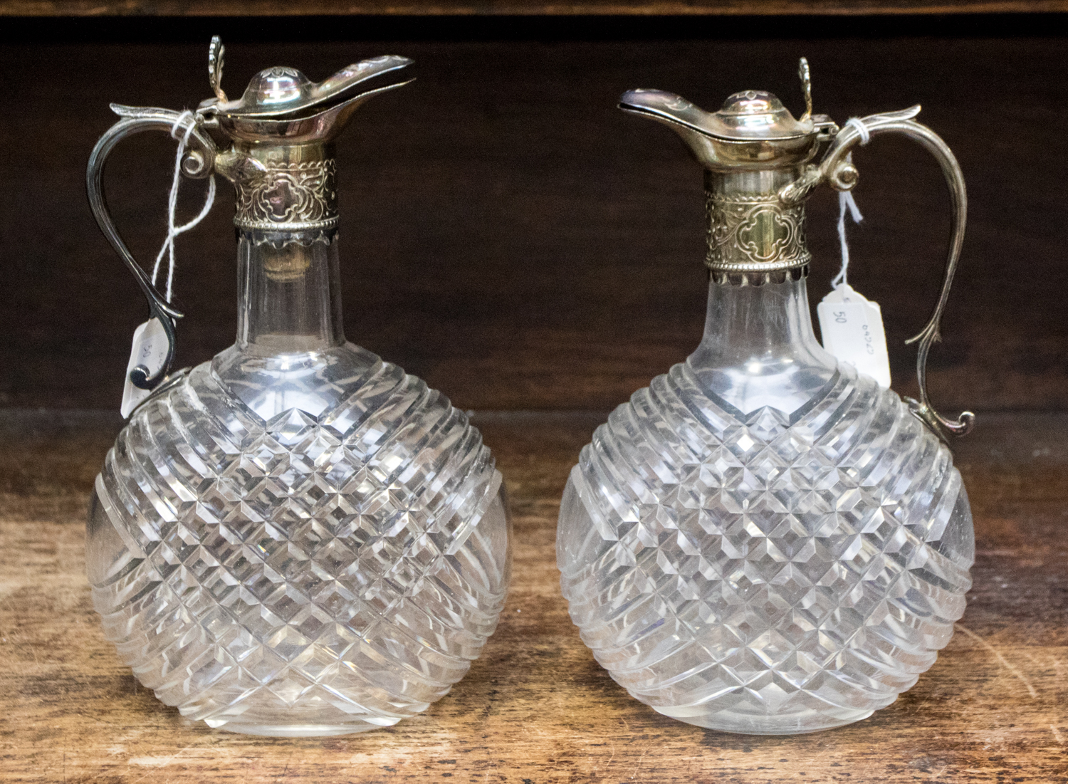 A near pair of late Victorian clear cut glass claret decanters with plated mounts (2)