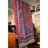 A large tribal Turkish/Afghan rug, red and blue with green,