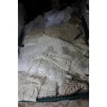 A large collection of cotton lace and a 1920s tablecloth edged with lace, trays, crochet mats,