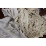 A cream silk shawl having cream embroidery and deep cream fringing