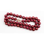 A single cultured pearl necklace stained crimson colour with 9ct gold clasp
