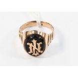 A gentlemen's oval signet ring set with a black onyx and overlaid gold the initials L.N.