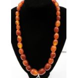 A burnt orange plastic bead necklace, graduated beads,