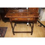 An early 18th Century oak joined side table, fitted with a single drawer, raised on turned legs,