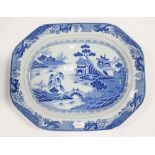 A large blue and white meat plate in the Willow pattern