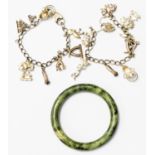 A hardstone spinach jadeite bangle together with two silver charm bracelets (silver approx 2.