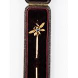 A rose and yellow metal stick pin, the finial designed as a fly, set with a sapphire and diamonds,