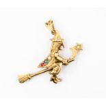A 9ct gold witch pendent with an articulated broomstick, set with paste red, blue and white stones,