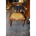 A 19th Century elm captains chair, raised on turned legs and joined by a double H stretcher,