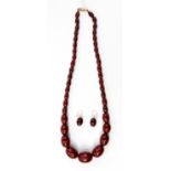 A graduated cherry amber style necklace with matching earrings, the necklace weighing approx 67.