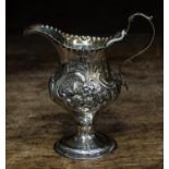Georgian silver, ogee shaped cream jug, sea scroll handle, body chased with foliage and scrolls,