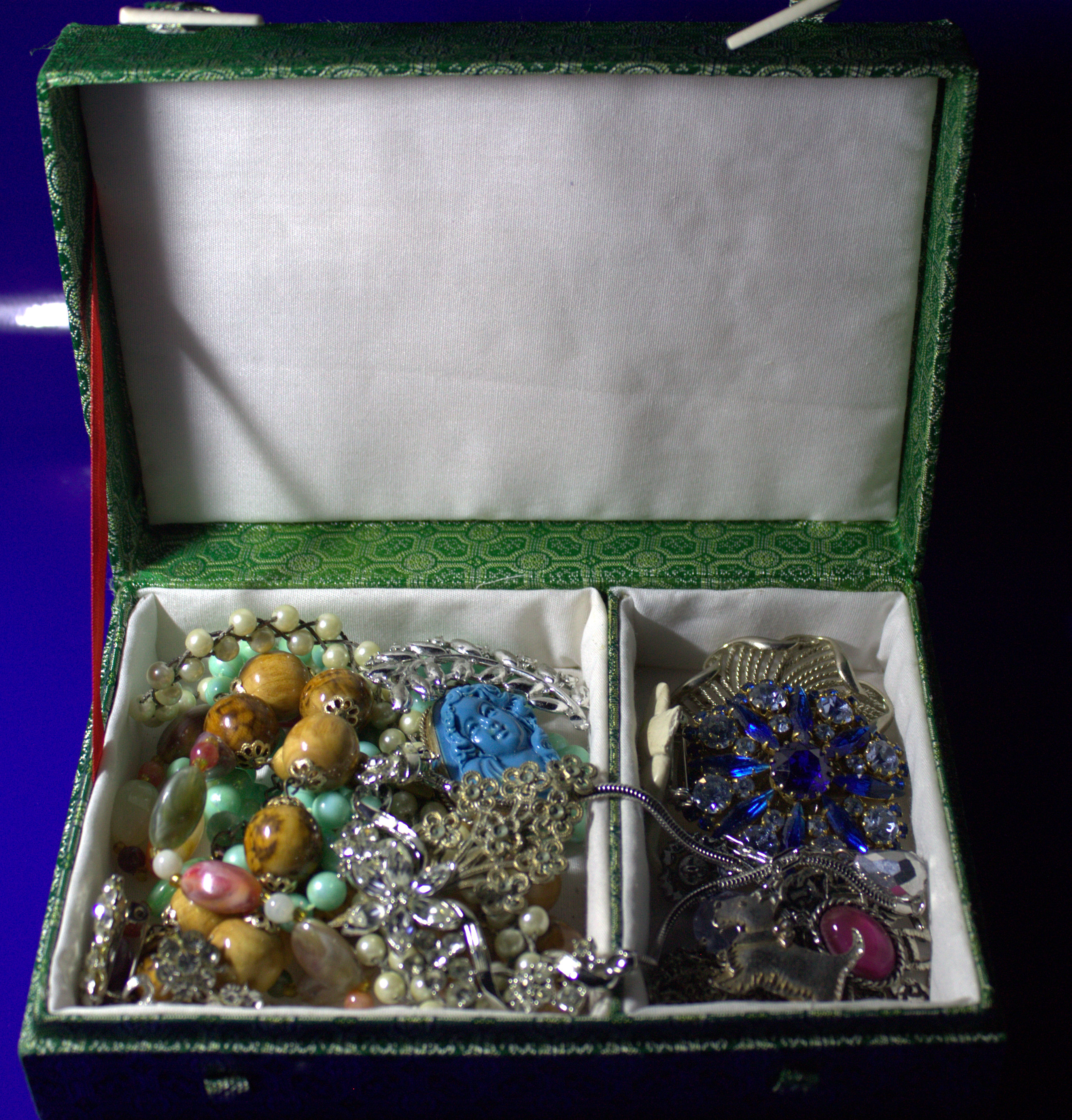 Box Containing A Mixed Lot Of Costume Jewellery To Include Brooches, Beads, Necklaces, Pendants Etc.