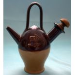 Unusual cream and brown glazed vessel with handle, spout and carved wood stopper. Marked to base '