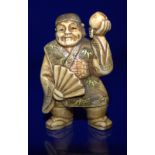 A Meiji Period Stained Ivory Netsuke Of A Man Holding A Peach, Signed To Base With Red Signature