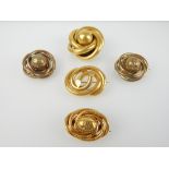 Five gold and yellow metal American style knot brooches,