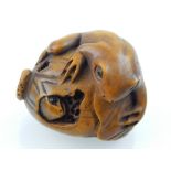 Japanese carved boxwood netsuke modelled as two toads eating a fruit, bears character mark. L.