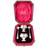 Early 20th century cased pair of silver salts and silver gilt condiment spoons,