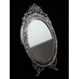 Persian silver easel dressing table mirror with oval plate within a pierced embossed floral border