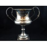 Silver plate inverted campana form twin-handled trophy cup on knopped stem,
