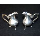 Pair of Swiss silver baluster cream jugs, Tezler 800 standard, ebonised handles on hoof feet,