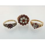 A 9ct gold, garnet and opal cluster ring and two other 9ct gold and garnet rings.