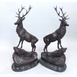 Pair of dark patinated bronzes of highland stags, modelled standing on rocky outcrops,