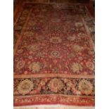 Afghan Ziegler red ground carpet woven with stylized flowerheads within a wide conforming border,