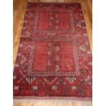 Persian Turkoman red ground carpet with two geometric panels within a wide border, 250 x 158cm.