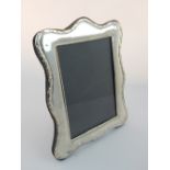 Silver mounted photograph frame, the serpentine shaped frame with a rectangular aperture and easel