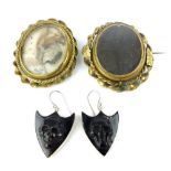 Two 19th C mourning brooches with ribbon twist frame and a pair of silver earrings with skull relief