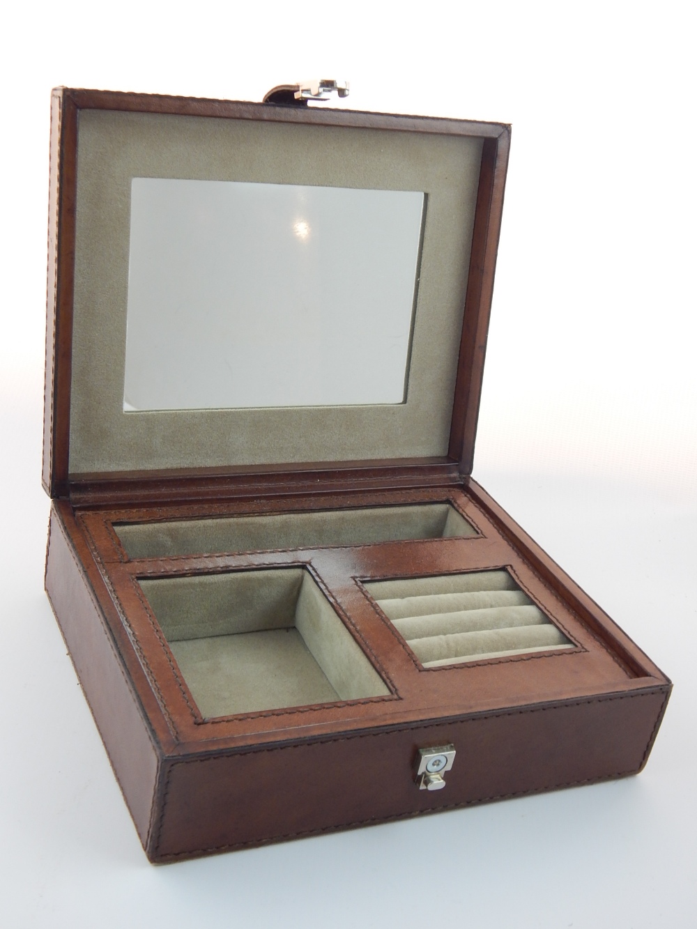 Tan leather jewellery box, the fitted interior with ring cushions and mirror, 21cm w