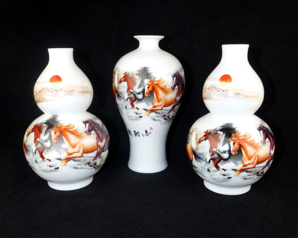 A garniture of three Chinese porcelain vases decorated with the eight horses of Wang Mu,