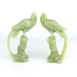 A pair of Chinese carved celadon jade phoenix birds perched on tree stumps, circa 1900s, 14cm